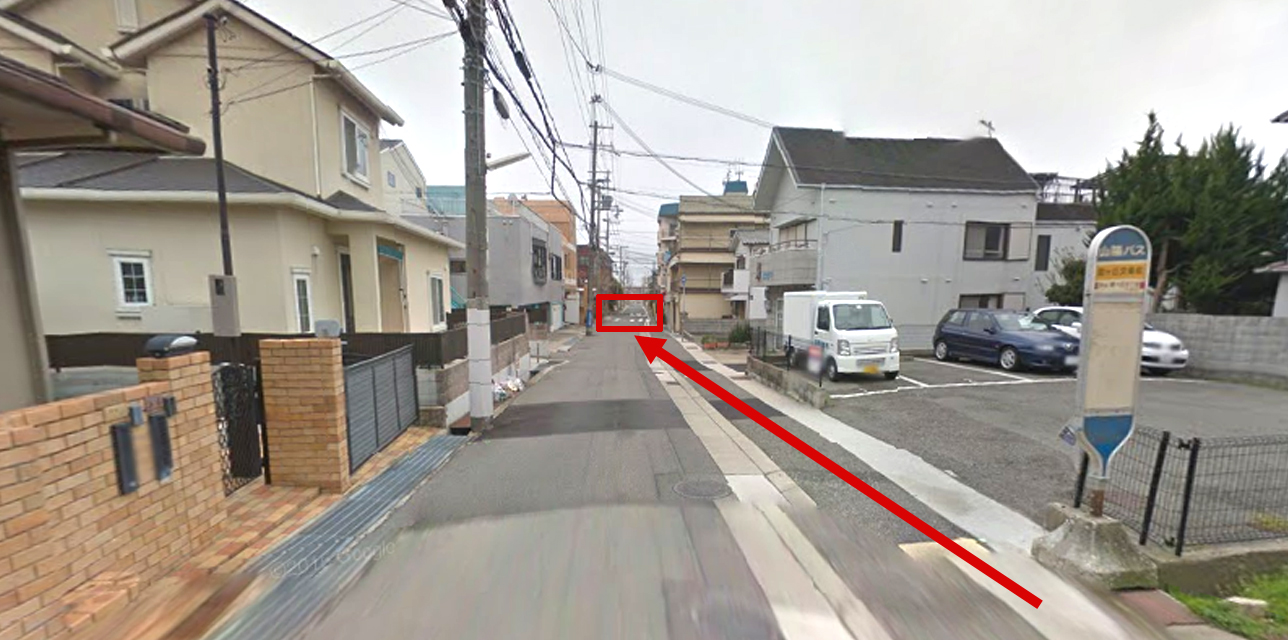 霞ヶ丘交番前(２つめの停留所)で下車してください。下車後、来た道をもどり一つ目の十字路(左手に交番があります)を左にまがります。
